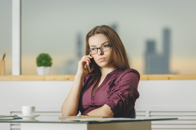 Vrouw op de werkplek aan de telefoon