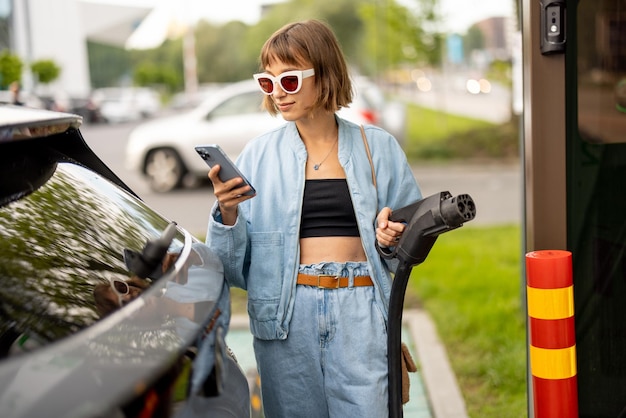 Vrouw op een oplaadstation voor elektrische auto's