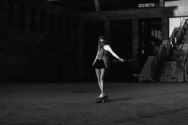 Vrouw op een skateboard in de stad mooie contrasterende zwart-wit foto van een rijdende vrouw