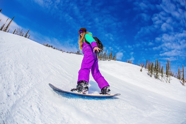 Vrouw op een snowboard in de bergen Sheregesh.