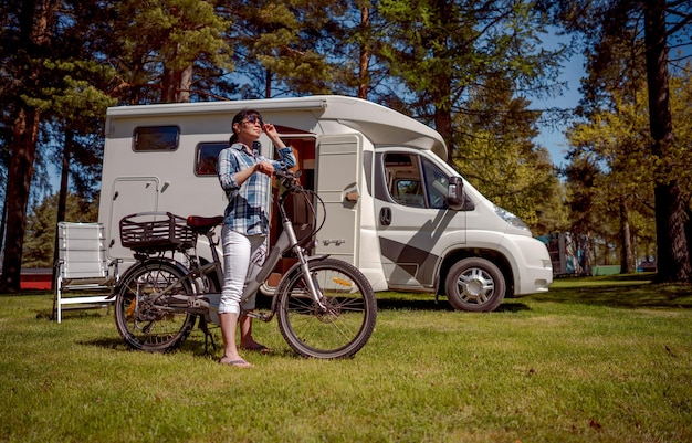 Vrouw op elektrische fiets die op de camping rust. Familie vakantiereizen, vakantiereis in camper, VR Caravan auto Vakantie.
