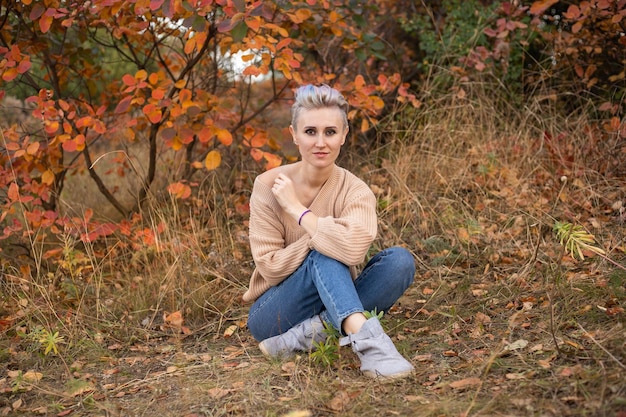 Vrouw op herfst bos achtergrond met gouden en rode bomen