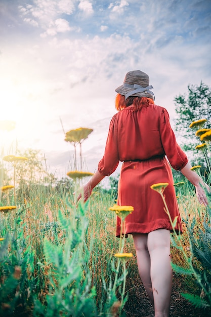 Vrouw op het gebied dat van de zonsondergang geniet