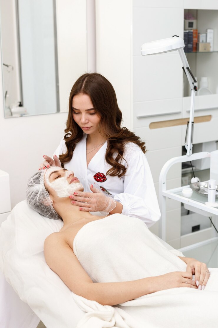 Vrouw op het gezicht met een masker op het kantoor van de schoonheidsspecialiste