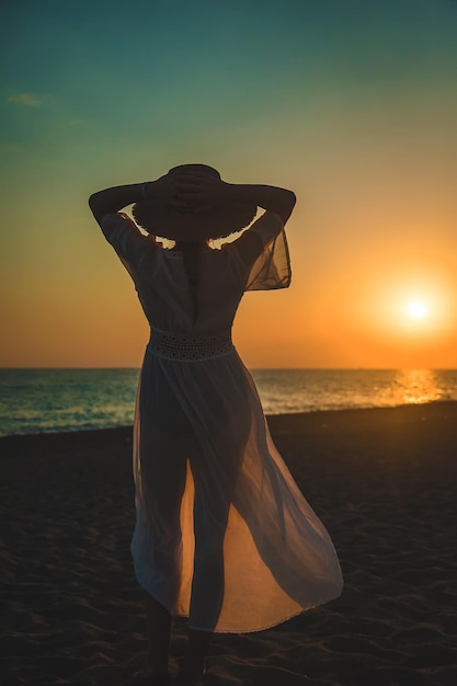 Vrouw op het strand bij zonsondergang. Selectieve aandacht.
