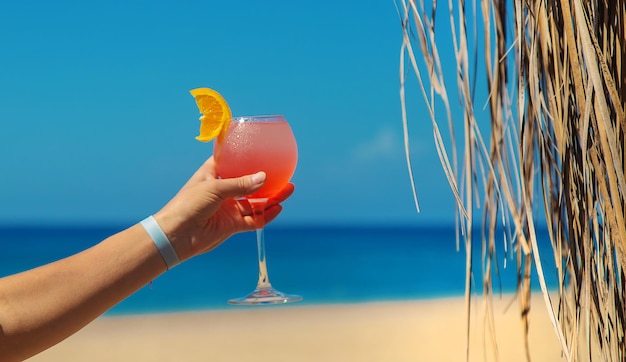 Vrouw op het strand met een cocktail in haar handen. Selectieve aandacht. Drankje.