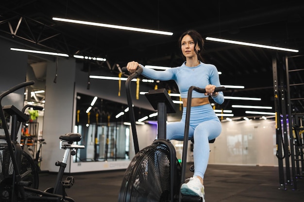 Vrouw op hometrainer in de sportschool