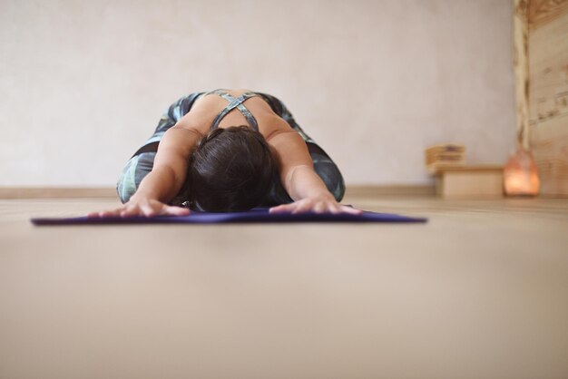 Vrouw op mat met uitgestrekte armen en handen in yoga asana Fondo de yoga