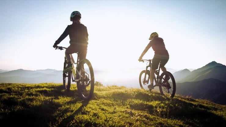 Foto vrouw op mountainbike bij zonsondergang
