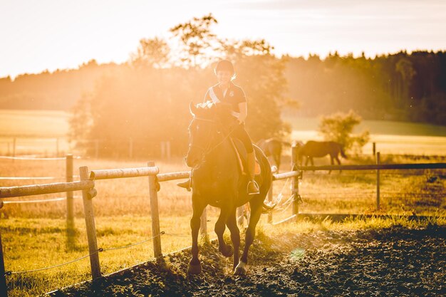 Foto vrouw op paard in de ranch.