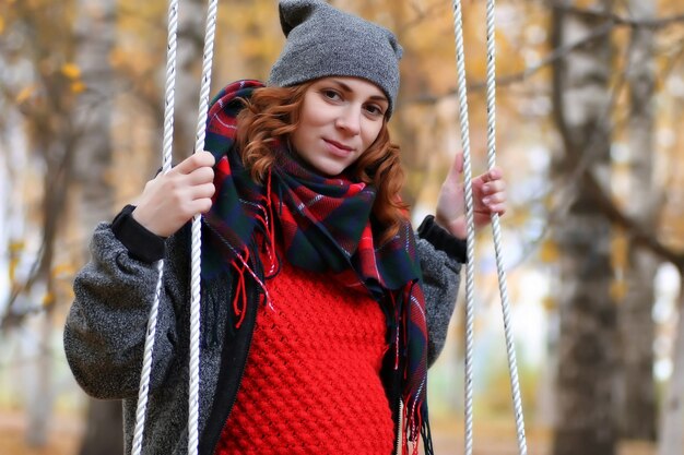 Vrouw op schommel in herfstpark