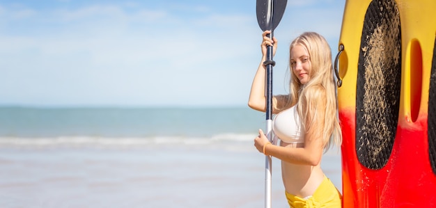 Vrouw op stand-up paddleboard. Plezier hebben tijdens een warme zomervakantie aan het strand, actieve vrouw