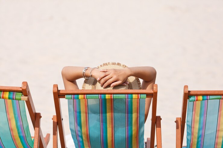 Vrouw op strandstoel die naar zee kijkt