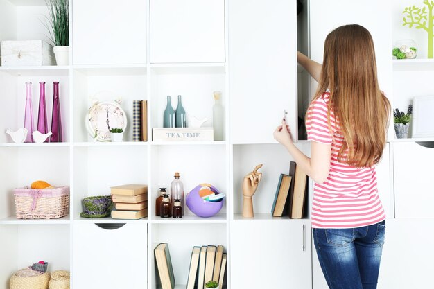 Foto vrouw op zoek naar iets in de kast in een kamer met modern interieur