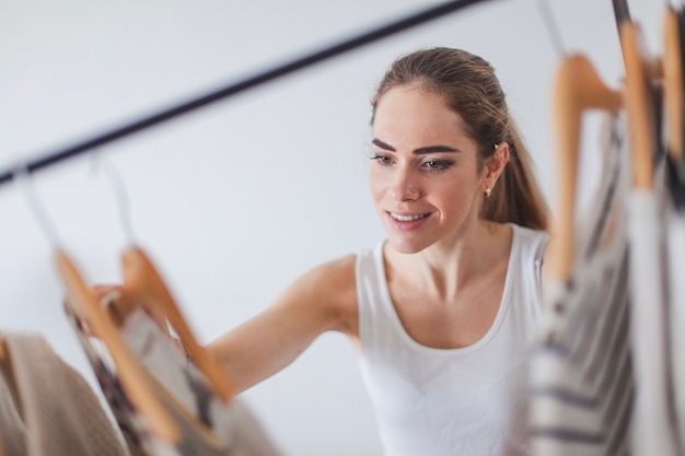 Foto vrouw op zoek naar kleding in kledingkast