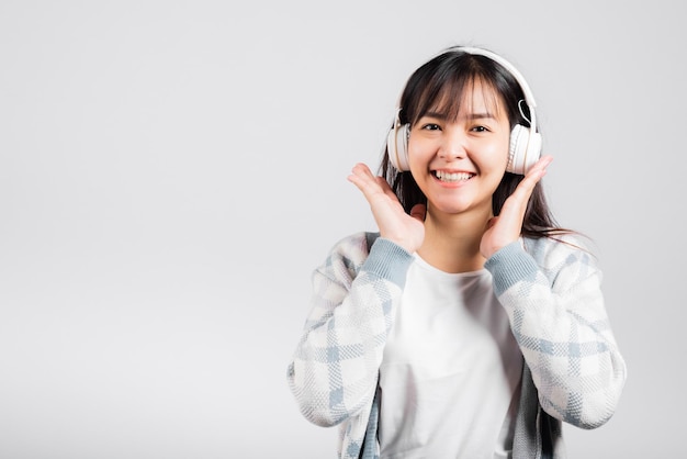 Vrouw opgewonden lachend luisteren naar muziek radio in bluetooth koptelefoon en telefoon vasthouden