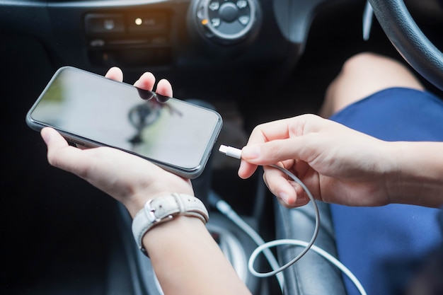 Vrouw opladen smartphone in auto.