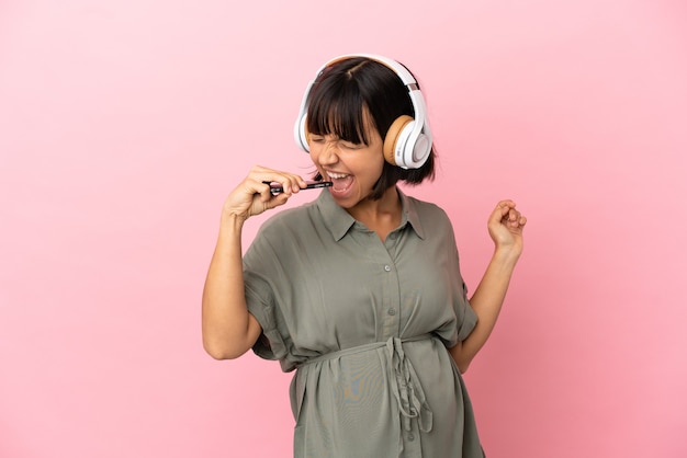 Vrouw over geïsoleerde achtergrond zwanger en dansen tijdens het luisteren naar muziek