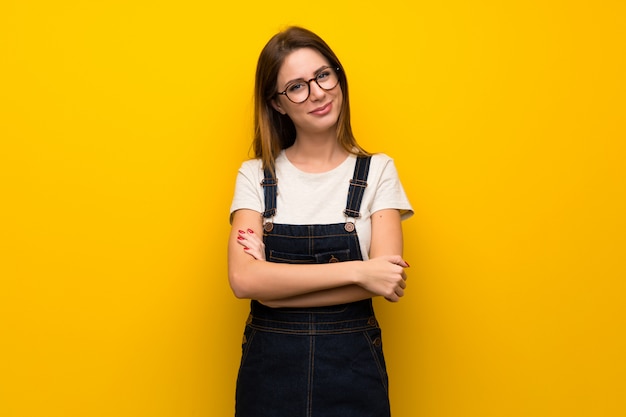 Vrouw over gele muur glimlachen