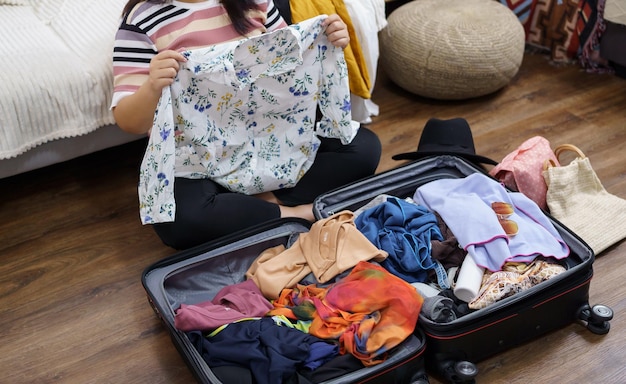 Vrouw pakt bagage in koffer voor nieuwe reis en pakt bagagereisplannen vakantie in