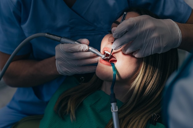 Vrouw patiënt in tandheelkundige kliniek wordt onderzocht door een mannelijke tandarts
