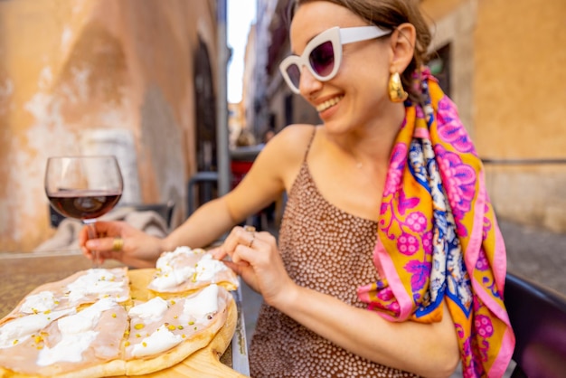 Vrouw pizza eten in Italiaans restaurant buitenshuis