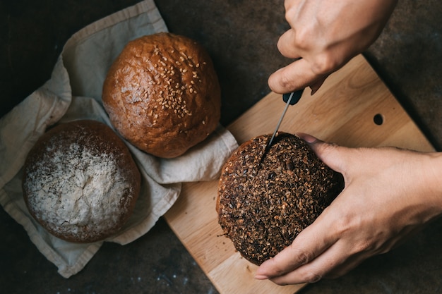 Vrouw plakjes broodje op houten bord