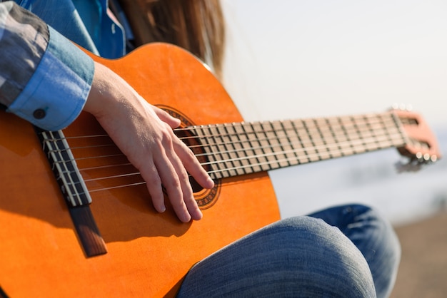 Vrouw playng gitaar de kust