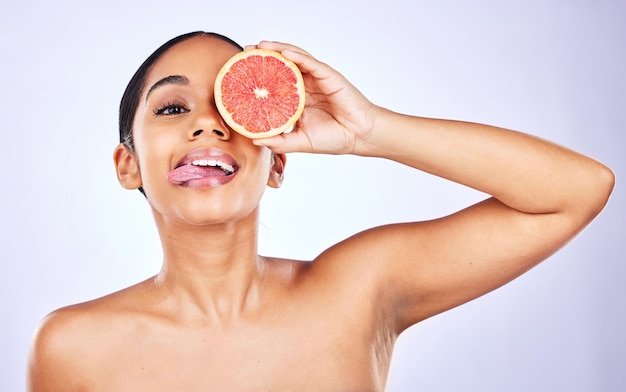 Vrouw portret en grapefruit voor natuurlijke schoonheid huidverzorging of cosmetica tegen een studio achtergrond Gezicht van vrouwelijke persoon met fruit voor gezonde voeding vitamine C of dieet en gezondheidszorg wellness