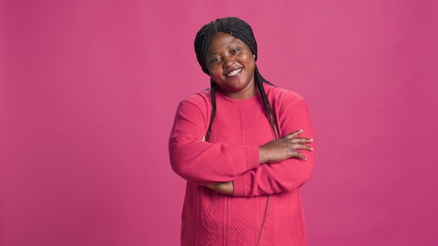 Vrouw poseert tegen een roze achtergrond