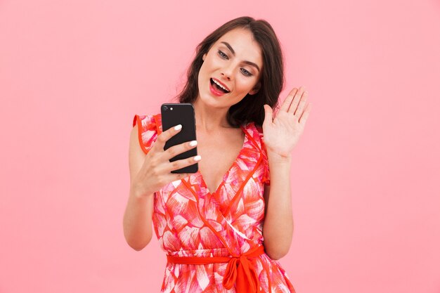 Vrouw poseren geïsoleerde muur praten door mobiele telefoon.