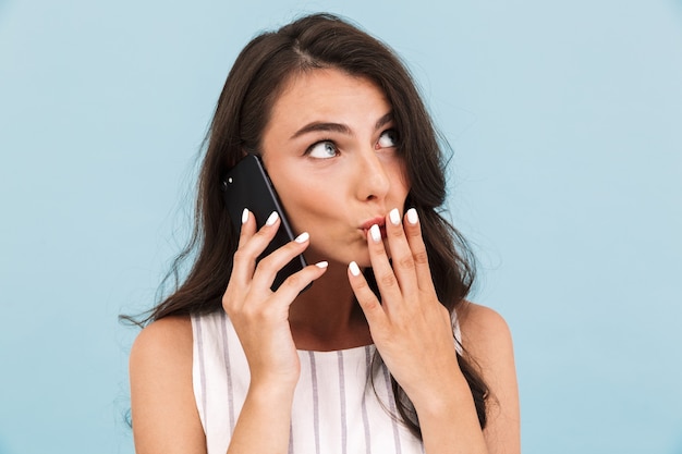 Vrouw poseren geïsoleerde muur praten door mobiele telefoon.