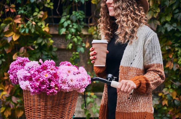 Vrouw poseren met vintage fiets en kopje koffie