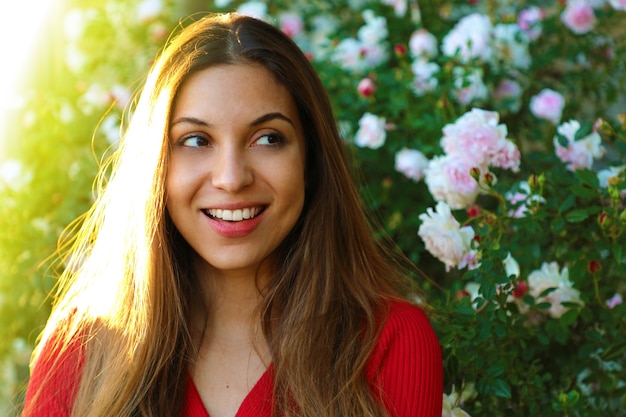 Vrouw poseren onder bloeiende rozen