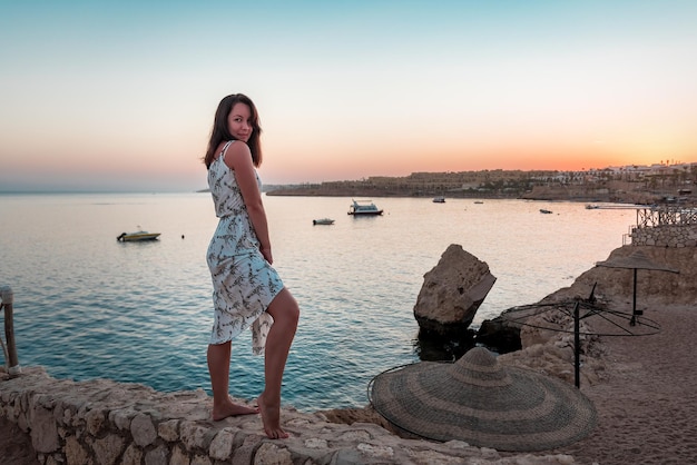 Vrouw poseren voor een foto in een badplaats bij zonsondergang