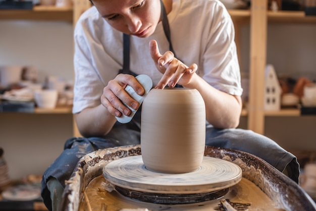 Vrouw pottenbakker bezig met een pottenbakkersschijf maken van een vaas