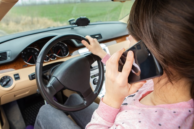 Vrouw praten op mobiele telefoon tijdens het rijden auto