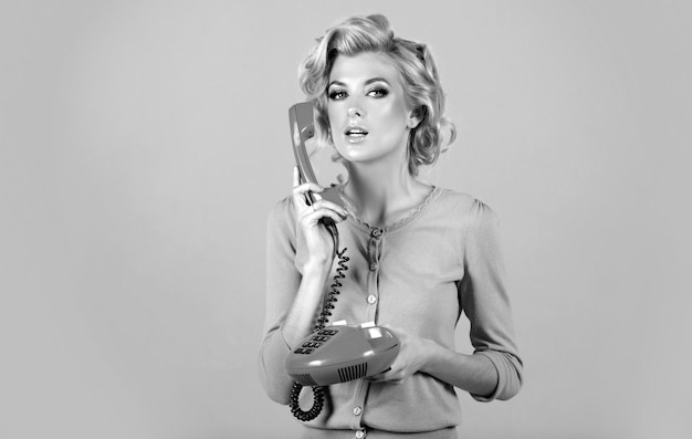 Vrouw praten op vaste telefoon retro-stijl geïsoleerd over roze achtergrond telefoon gesprek portrai