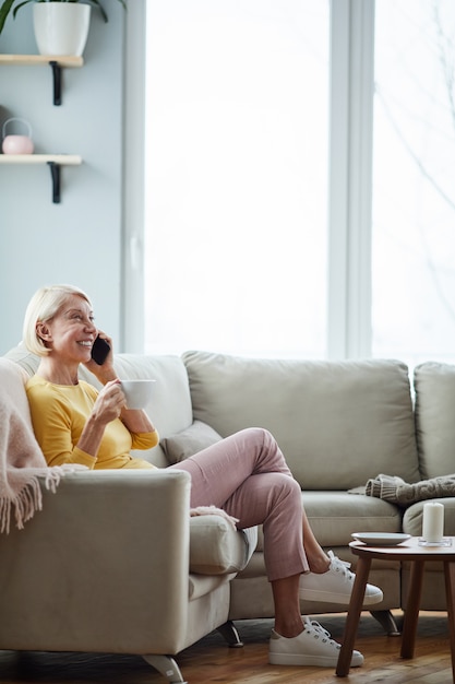 Vrouw praten over de telefoon in de woonkamer