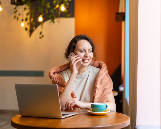 Vrouw praten over telefoon bij coffeeshop