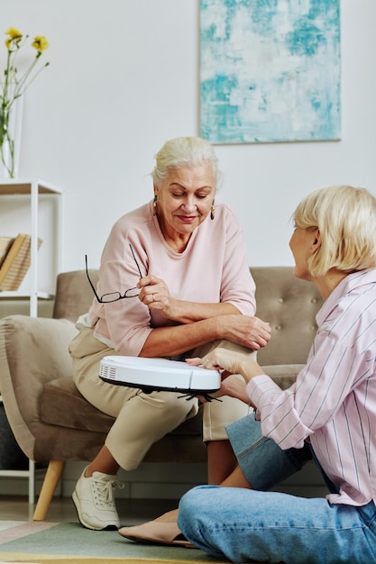 Vrouw presenteert slimme stofzuiger aan senior moeder