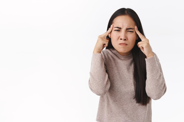 Vrouw probeert te vernietigen met kracht van denken, loensen en boos kijken, woedend, vloek rivaal in gedachten, aanraken tempels fronsen, grimassen gehinderd, staande