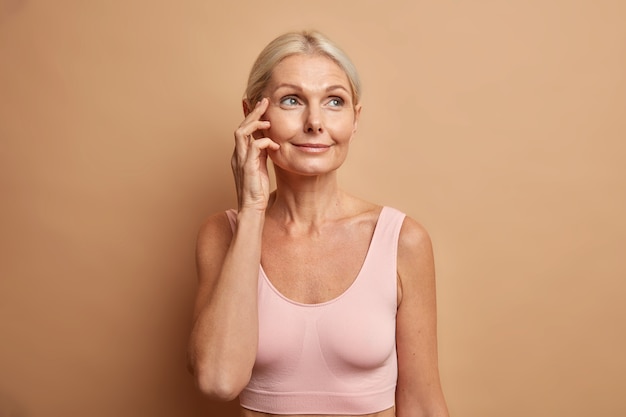 vrouw raakt gezicht heeft gezonde huid na cosmetische ingrepen of gezichtsbehandelingen