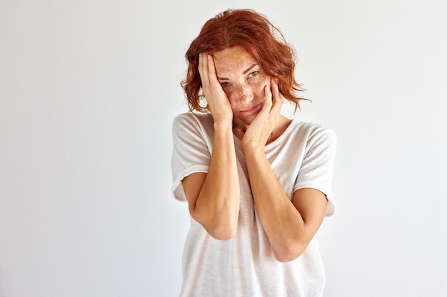 Vrouw raakt haar gezicht aan, ze is van streek door iets, depressief