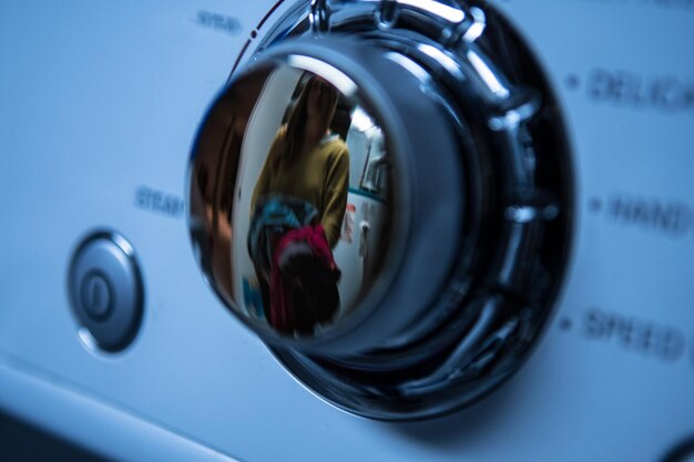 Foto vrouw reflecteert op de knop van de wasmachine