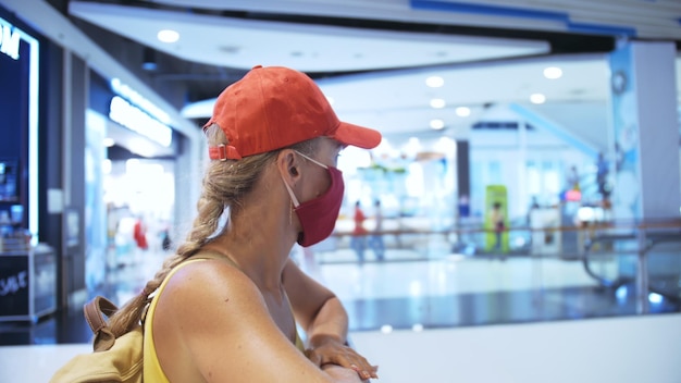 Vrouw reist kaukasische bezoeker in een supermarkt met een beschermend medisch masker Meisjestoeristenklant een supermarkt met beschermend ademhalingsapparaat