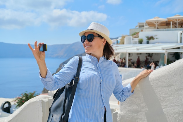 Vrouw reisvlogger reist in het Griekse dorp Oia op het eiland Santorini, filmt video
