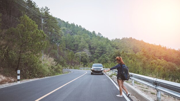 vrouw reizen. Vrouwen backpacken reizen stand wuivende auto. Surfvakanties