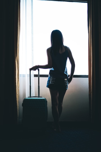 vrouw reiziger draagt ​​een bagage en check-in naar het hotel.