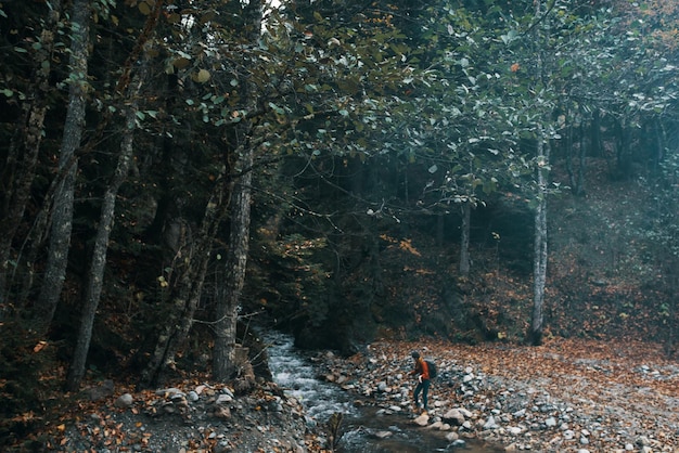 Vrouw reiziger in de buurt van een berg rivier in het bos zit aan de kust herfst landschap